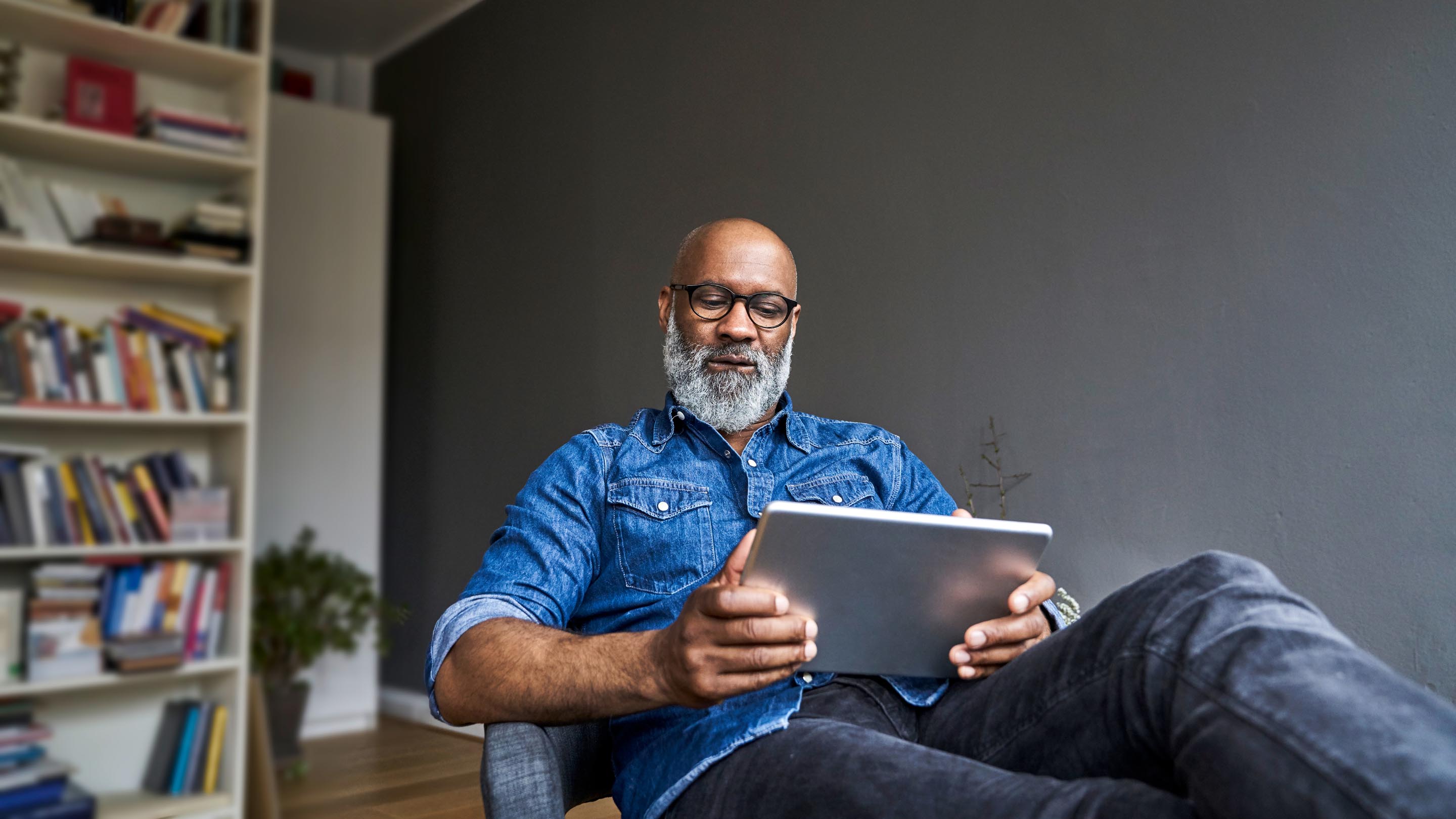 Mature man sitting down using a tablet